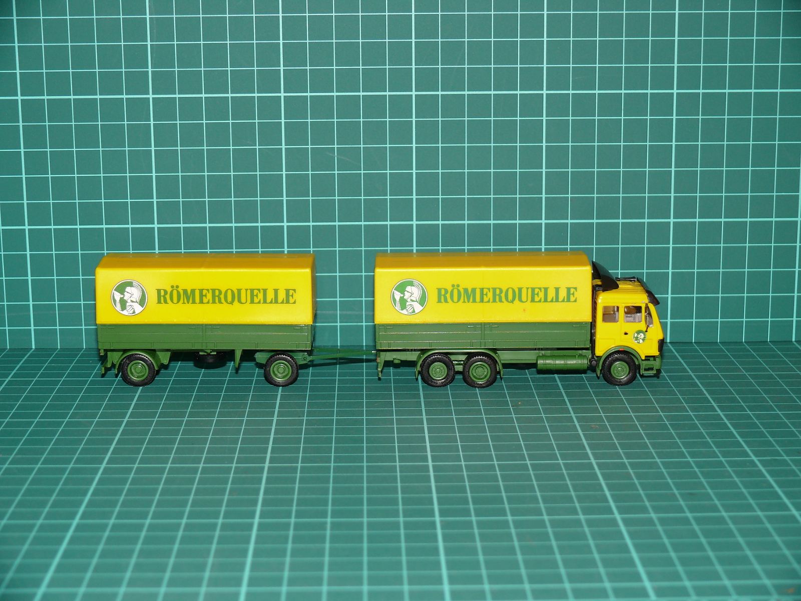 Herpa - Mercedes-Benz NG Nákladní souprava s vlekem „RÖMERQUELLE“ – H0