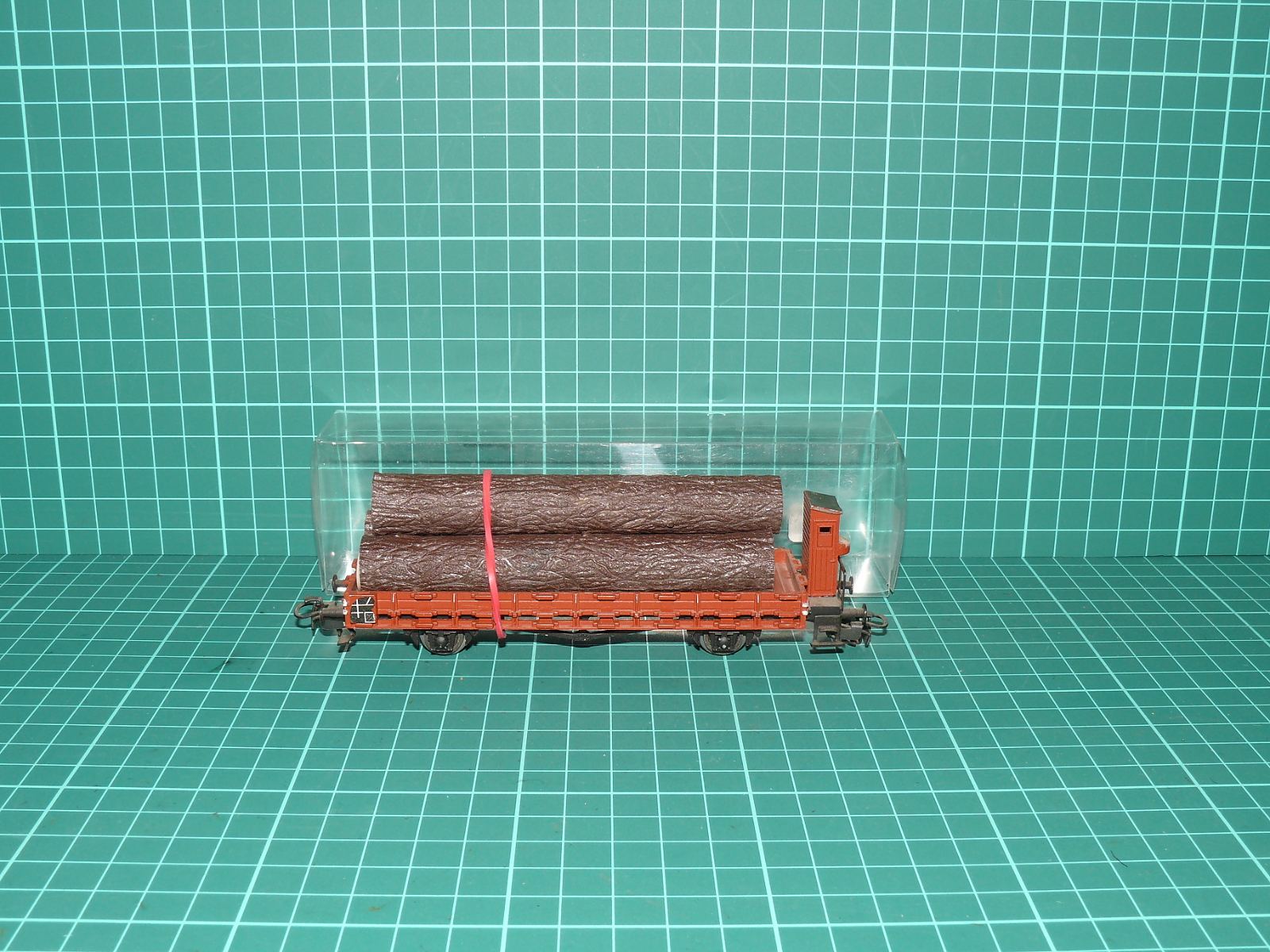 Trix H0 44553 - Nízkostěnný plošinový vůz s brzdařskou budkou a nákladem kmenů (1:87) OVP – H0