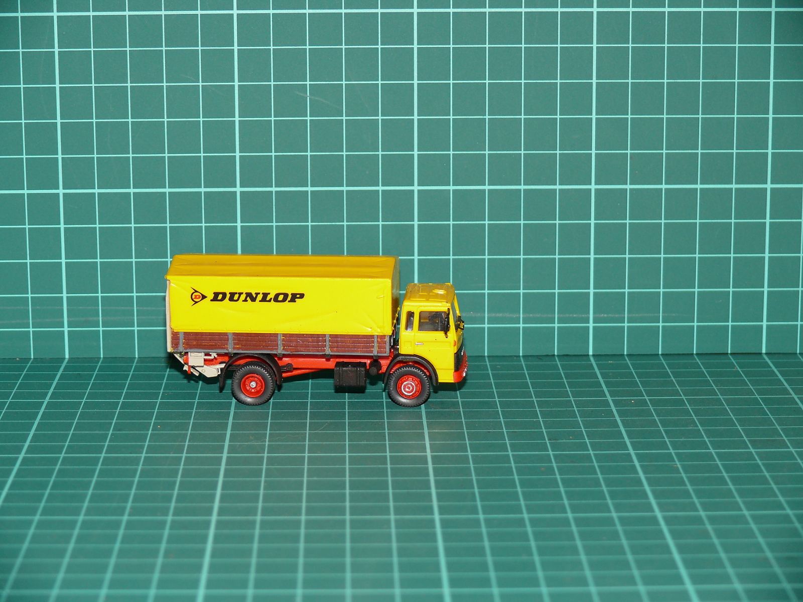 Wiking / Herpa - MAN / Büssing Dvounápravový valník s plachtou a čelem „DUNLOP“ – H0