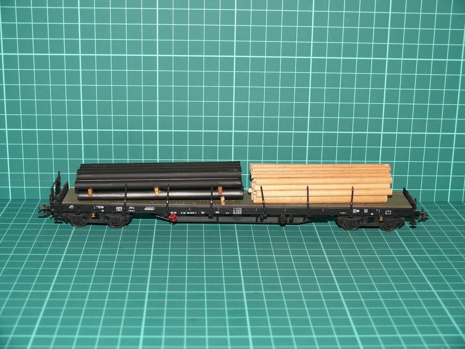 Roco H0 - Čtyřnápravový plošinový / klanicový vůz Rgs DB s nákladem ocelových trubek a kulatiny černý (1:87) – H0