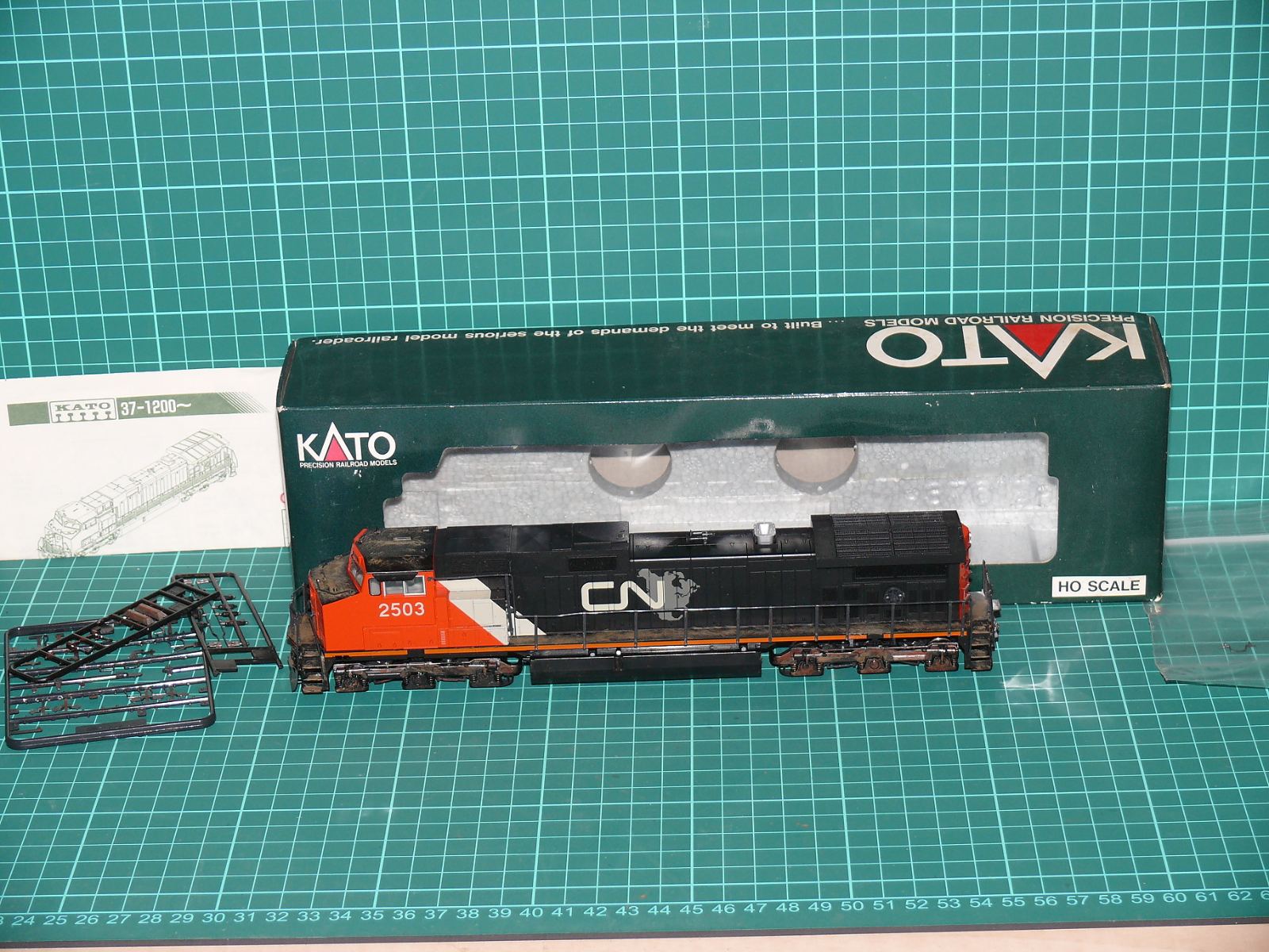 KATO 37-1202 H0 - Těžká šestinápravová dieselová lokomotiva GE C44-9W „Dash 9“ (CN #2503) Canadian National s patinou a doplňky v krabičce (1:87) – H0