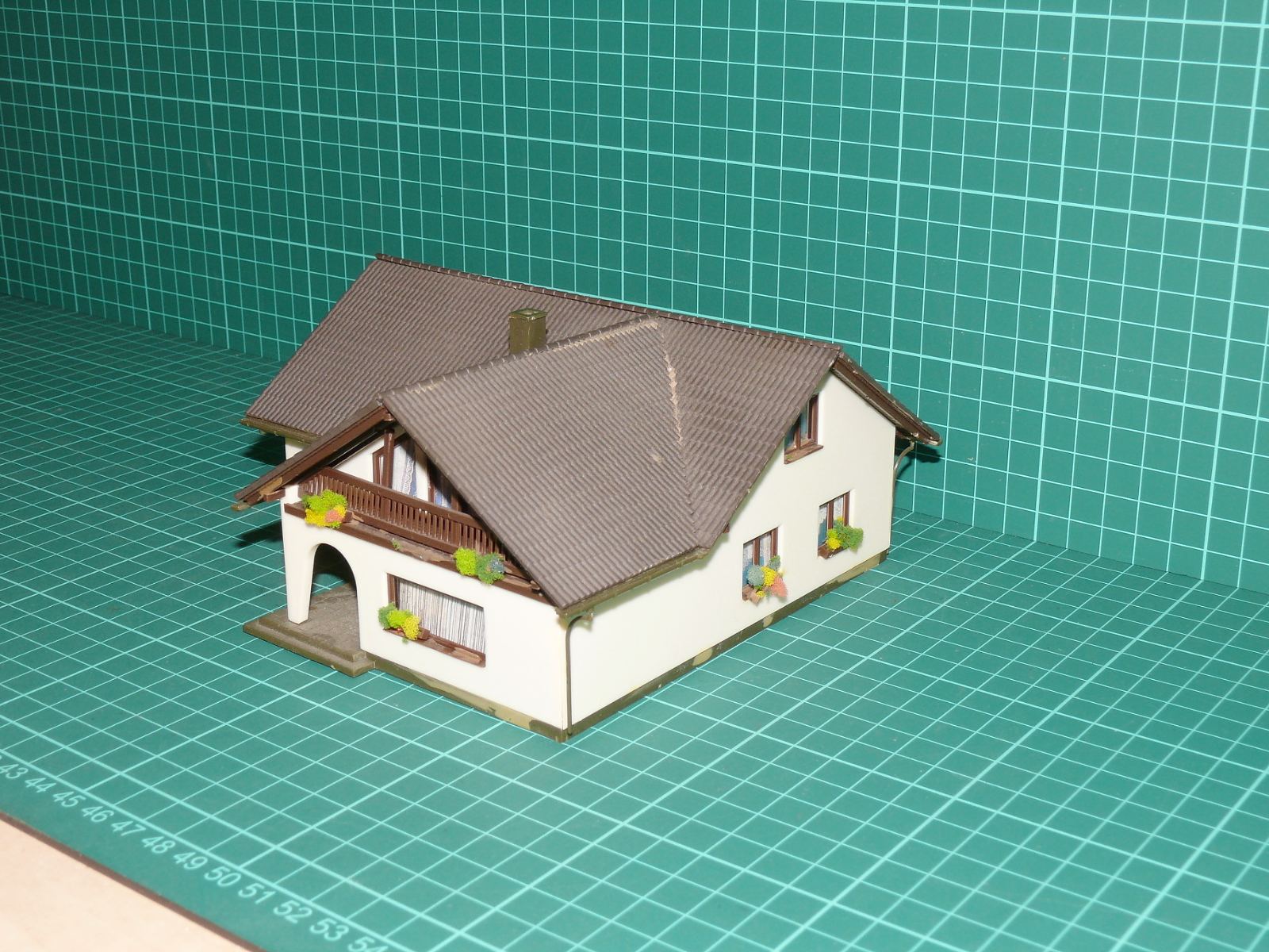 H0 – Venkovský rodinný dům / alpská vila do L s balkonem a krytou terasou (sestavený model) – H0