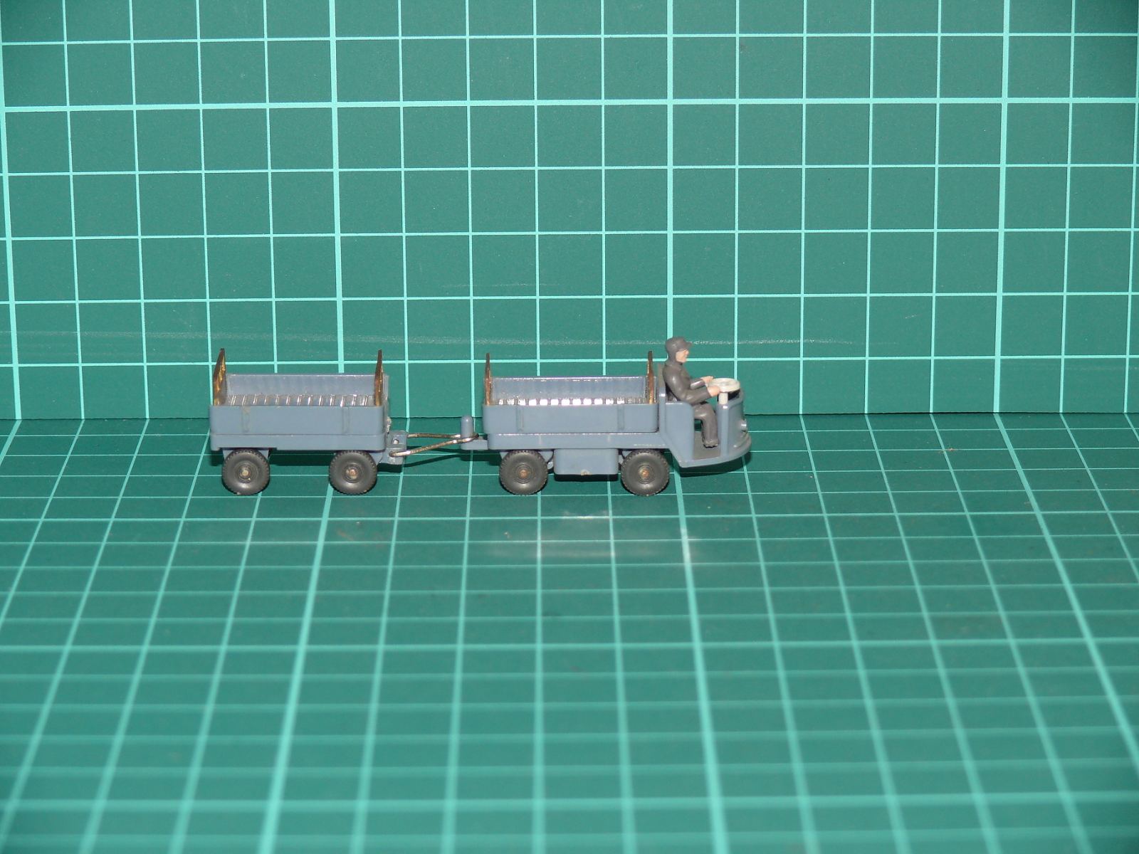Wiking H0 – Nádražní / letištní elektrovozík s řidičem a vlekem, šedá (1:87) – H0