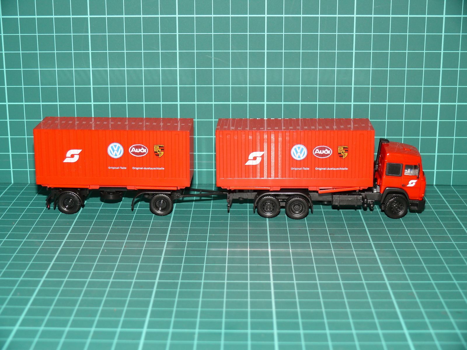 Herpa H0 – Kontejnerová souprava Iveco s vlekem „V.A.G / VW Audi Porsche – Original-Teile“ (1:87) – H0