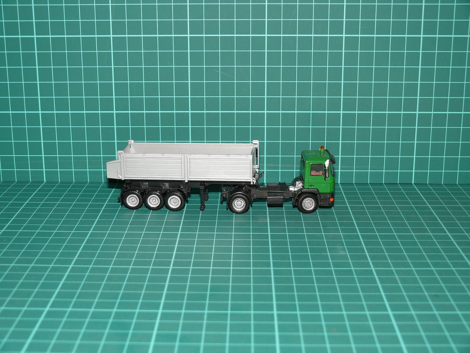 Herpa H0 – Stavební tahač MAN F90 se sklápěcím návěsem / muldou (zeleno-stříbrný) – H0