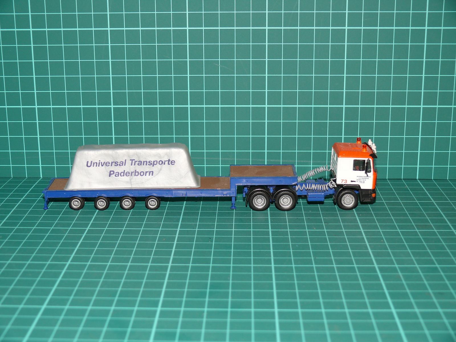 Herpa H0 – Těžkotonážní tahač MAN F90 3-osý s hlubinným návěsem a krytým nákladem „Universal Transporte Paderborn“ – H0