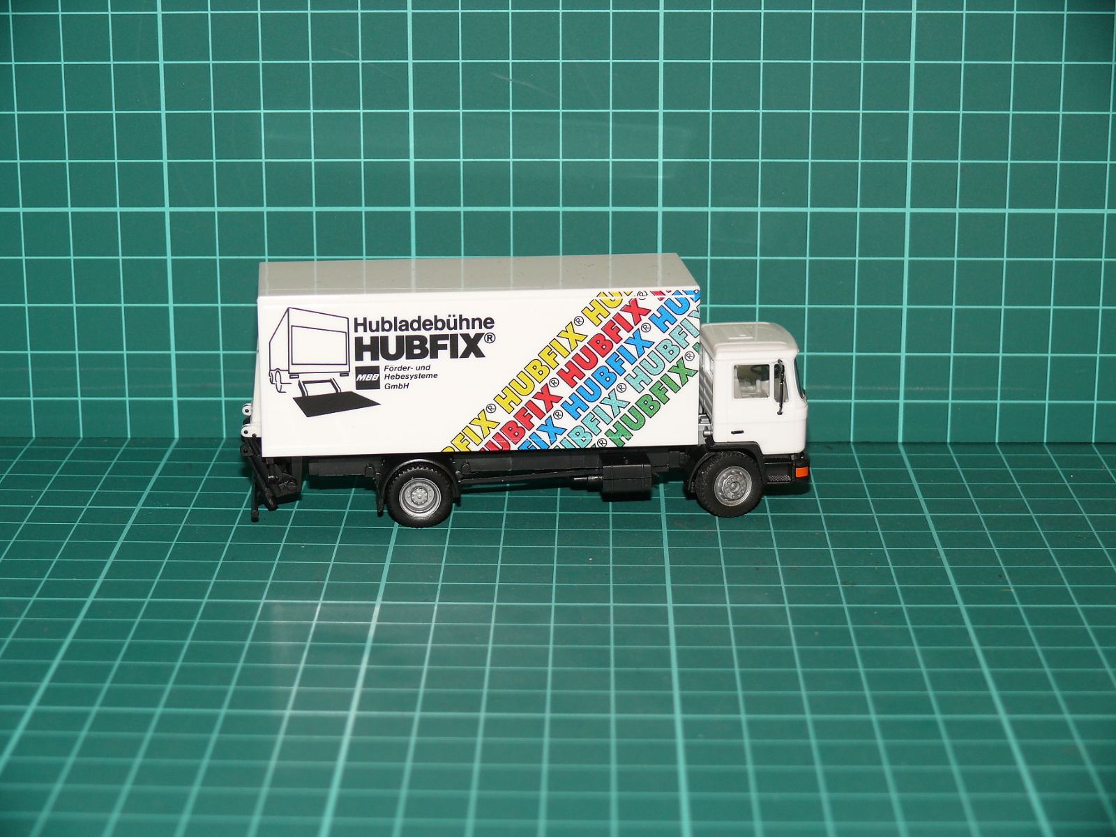 Herpa H0 – Skříňový nákladní automobil MAN F90 se zadním zvedacím čelem „Hubladebühne HUBFIX“ – H0