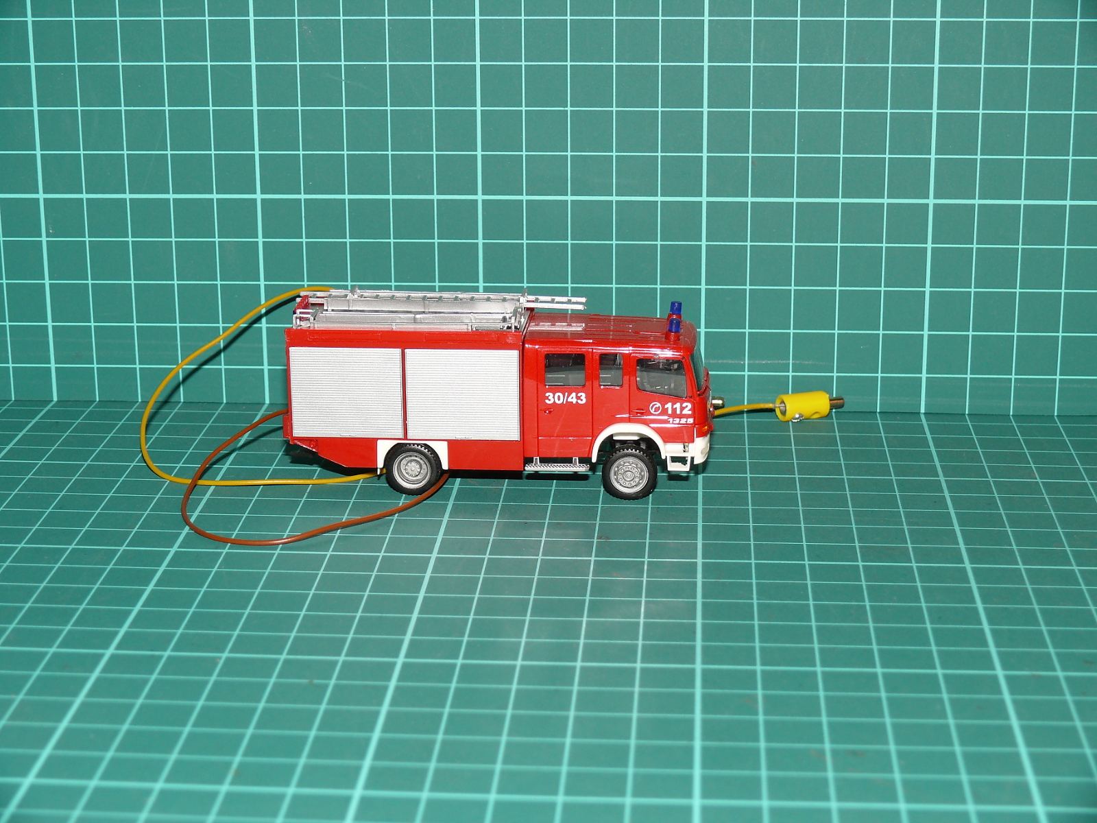 H0 (1:87) – Hasičská cisternová stříkačka / zásahový vůz Mercedes-Benz Atego s elektroinstalací a majáky – H0