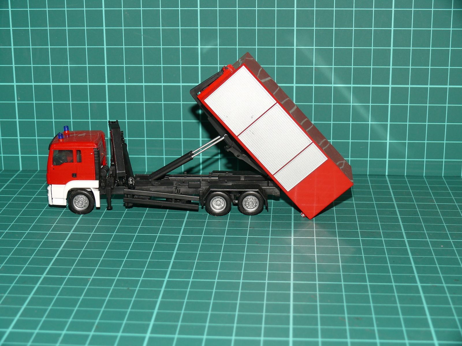 Herpa / Wiking H0 (1:87) – MAN TGS hasičský třínápravový nosič kontejnerů s výměnnou nástavbou (Abrollkipper) – H0